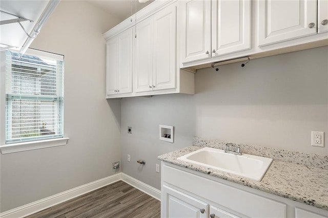 washroom with washer hookup, gas dryer hookup, baseboards, cabinet space, and dark wood finished floors