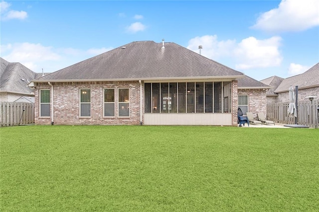 rear view of house with a yard, a fenced backyard, and brick siding