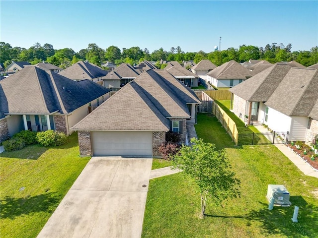 view of front of house with an attached garage, brick siding, fence, and a residential view