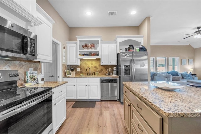 kitchen featuring light wood finished floors, a sink, open floor plan, visible vents, and appliances with stainless steel finishes