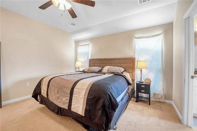 bedroom with light colored carpet, ceiling fan, baseboards, and visible vents