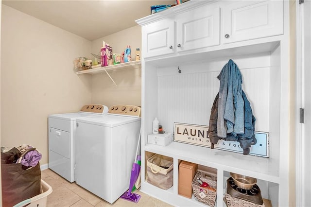 laundry area with washer and dryer, light tile patterned floors, and cabinet space