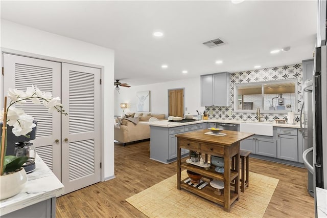 4716 Elmwood Pkwy, Metairie, LA 70003 - kitchen with stainless steel dishwasher, a sink, visible vents, backsplash, and gray cabinets