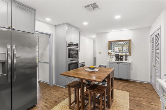 4716 Elmwood Pkwy, Metairie, LA 70003 - kitchen featuring gray cabinets, wood finished floors, stainless steel appliances, and visible vents