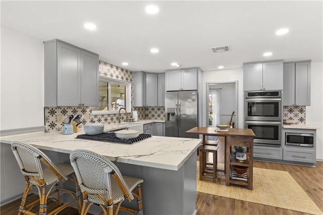 4716 Elmwood Pkwy, Metairie, LA 70003 - kitchen featuring light stone counters, gray cabinetry, and stainless steel appliances