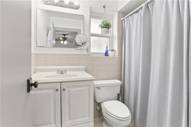4716 Elmwood Pkwy, Metairie, LA 70003 - full bathroom with tile patterned floors, toilet, vanity, tile walls, and ceiling fan