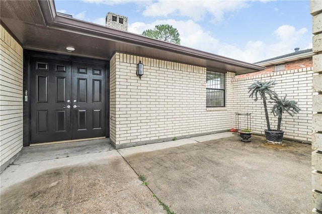 1534 Holiday Pl, New Orleans, LA 70131 - doorway to property featuring a chimney, brick siding, and a patio