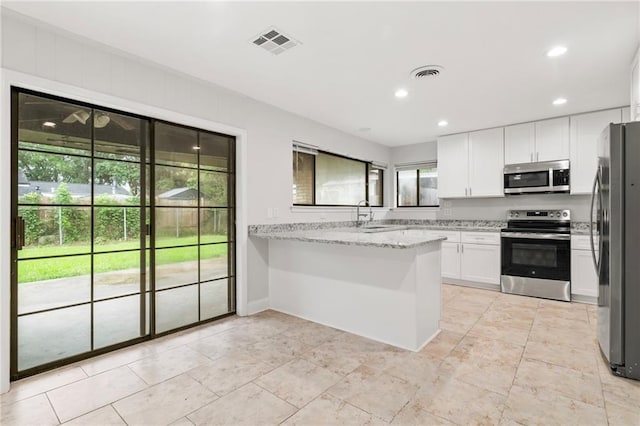 1534 Holiday Pl, New Orleans, LA 70131 - kitchen featuring white cabinets, stainless steel appliances, a peninsula, and visible vents