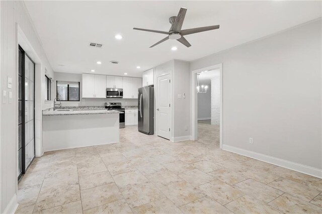 1534 Holiday Pl, New Orleans, LA 70131 - kitchen with ceiling fan with notable chandelier, open floor plan, white cabinetry, and appliances with stainless steel finishes