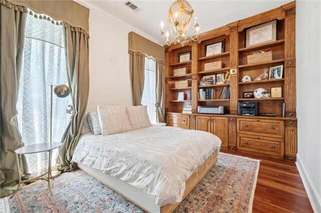 bedroom with baseboards, visible vents, a notable chandelier, wood finished floors, and crown molding