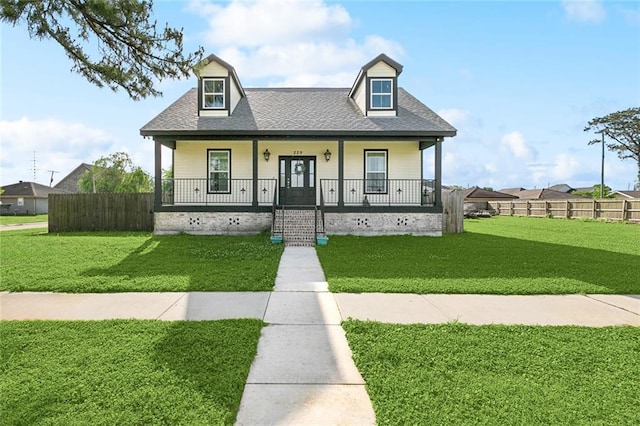 new england style home featuring fence, a front yard, and covered porch
