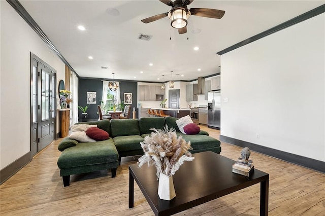 living room with baseboards, crown molding, visible vents, and recessed lighting