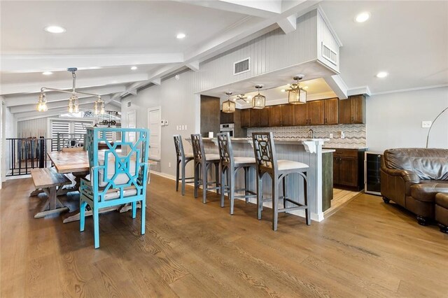7930 Breakwater Drive 52&53, New Orleans, LA 70124 - dining space with beverage cooler, visible vents, light wood finished floors, and beam ceiling