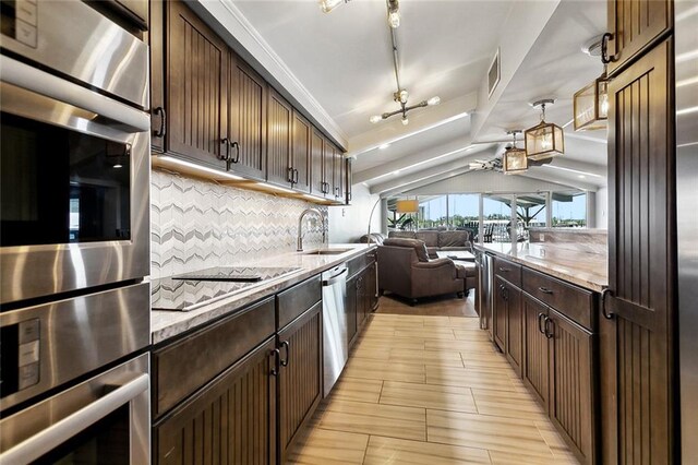 7930 Breakwater Drive 52&53, New Orleans, LA 70124 - kitchen featuring a sink, tasteful backsplash, dark brown cabinets, open floor plan, and appliances with stainless steel finishes