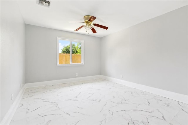 unfurnished room with marble finish floor, baseboards, a ceiling fan, and visible vents