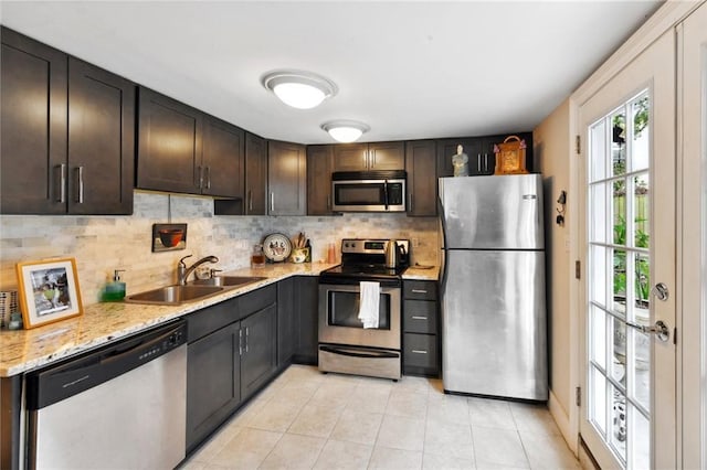 615 Filmore Ave, New Orleans, LA 70124 - kitchen featuring stainless steel appliances, tasteful backsplash, light tile patterned floors, dark brown cabinetry, and light stone countertops