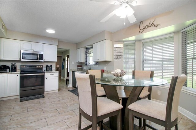 2172 Carmel Valley Dr, La Place, LA 70068 - dining area featuring light tile patterned floors, a ceiling fan, visible vents, baseboards, and a textured ceiling