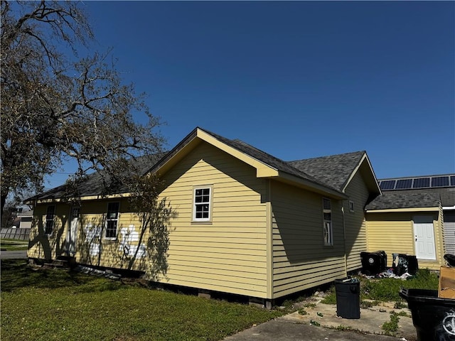 2003 Spain St, New Orleans, LA 70117 - view of side of property featuring a lawn and a shingled roof