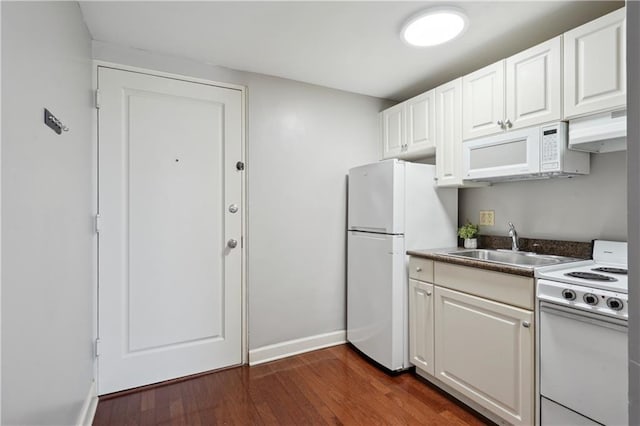 1205 St Charles Ave Unit 714, New Orleans, LA 70130 - kitchen featuring a sink, baseboards, white appliances, under cabinet range hood, and dark wood-type flooring