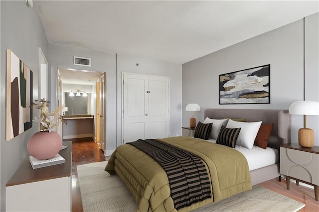1205 St Charles Ave Unit 714, New Orleans, LA 70130 - bedroom with wood finished floors, visible vents, a closet, and ensuite bathroom