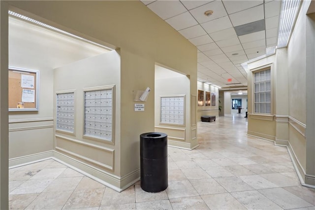 1205 St Charles Ave Unit 714, New Orleans, LA 70130 - hallway featuring baseboards, mail area, a paneled ceiling, and tile patterned flooring