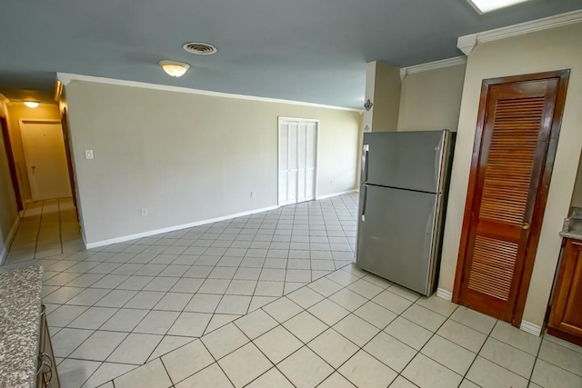 1021 Maplewood Dr, Harvey, LA 70058 - kitchen featuring light tile patterned floors, ornamental molding, freestanding refrigerator, and baseboards