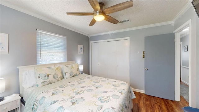 31763 Shelton Dr, Springfield, LA 70462 - bedroom with a textured ceiling, visible vents, wood finished floors, a closet, and crown molding