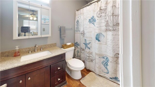 31763 Shelton Dr, Springfield, LA 70462 - bathroom with a shower with curtain, toilet, a ceiling fan, wood finished floors, and vanity