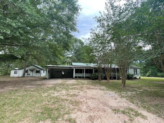 46038 Wooding Ln, Franklinton, LA 70438 - view of front facade featuring an attached carport, driveway, a front lawn, and metal roof