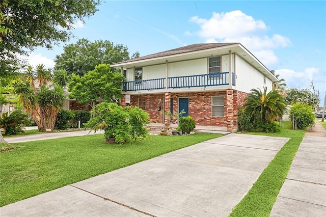 716 N Woodlawn Ave, Metairie, LA 70001 - view of front of property featuring a balcony, driveway, a front yard, and brick siding