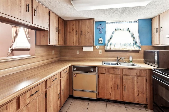 716 N Woodlawn Ave, Metairie, LA 70001 - kitchen with black appliances, a sink, a textured ceiling, light countertops, and light tile patterned floors