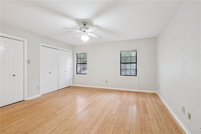 4738 Banks St, New Orleans, LA 70119 - unfurnished bedroom with multiple closets, light wood-style flooring, and a ceiling fan