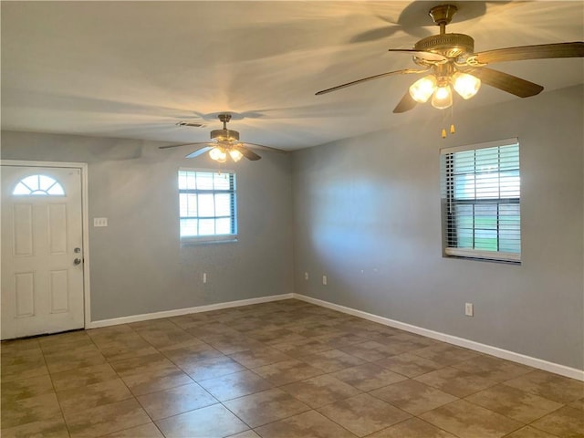 tiled foyer entrance with baseboards, a ceiling fan, and visible vents