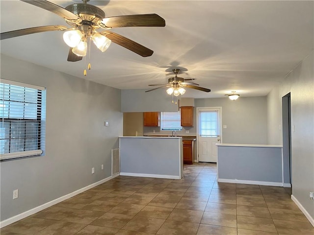 3412 Shannon Dr, Violet, LA 70092 - kitchen featuring a peninsula, baseboards, light countertops, tile patterned floors, and a ceiling fan