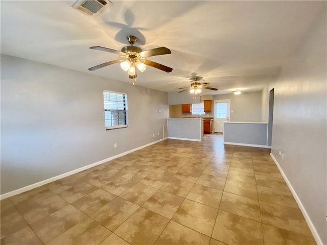 unfurnished living room with visible vents, a ceiling fan, baseboards, and light tile patterned floors