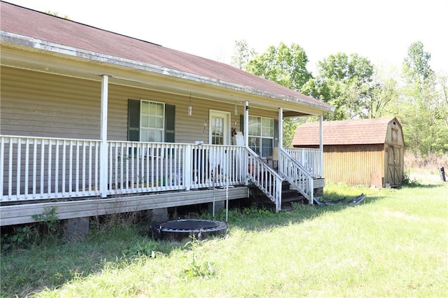 entrance to property with a porch and a lawn