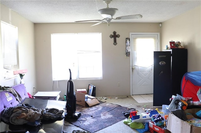 bedroom featuring a ceiling fan, multiple windows, and a textured ceiling