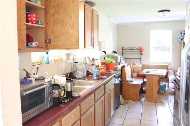 kitchen featuring open shelves, a sink, a toaster, and light tile patterned floors