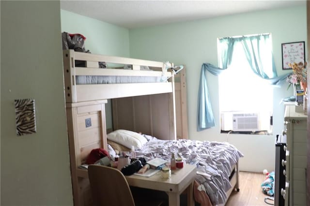 bedroom featuring wood finished floors and cooling unit