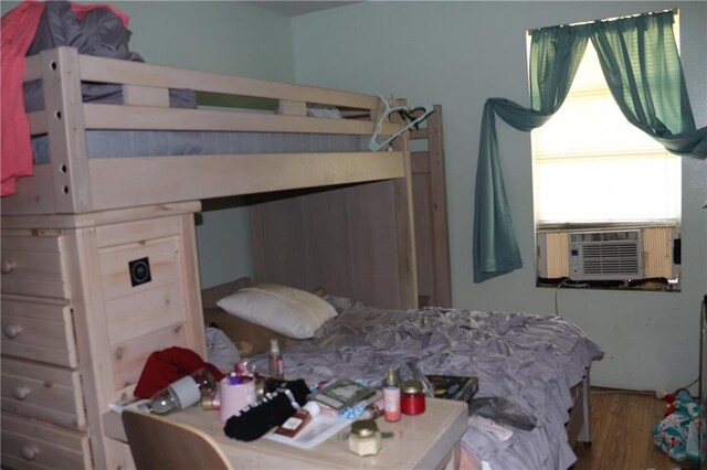 bedroom featuring cooling unit and wood finished floors