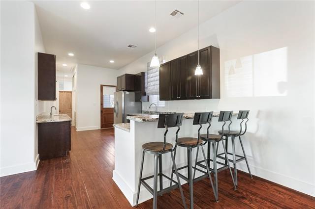 842 Toledano St, New Orleans, LA 70115 - kitchen featuring dark wood-style floors, visible vents, baseboards, freestanding refrigerator, and light stone countertops