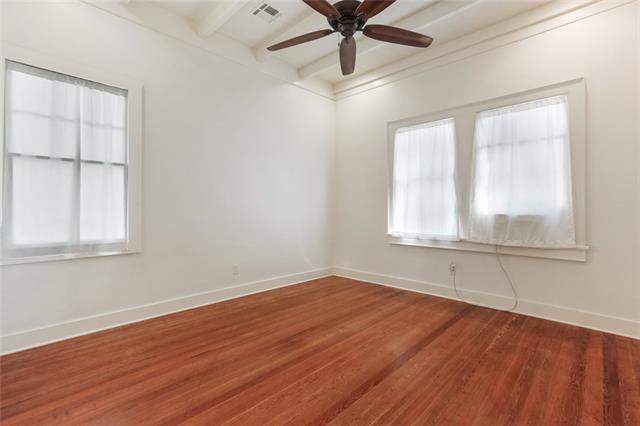 842 Toledano St, New Orleans, LA 70115 - empty room with wood finished floors, ceiling fan, baseboards, beam ceiling, and visible vents