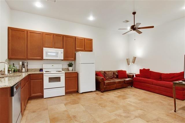 842 Toledano St, New Orleans, LA 70115 - kitchen with ceiling fan, brown cabinetry, a sink, and white appliances