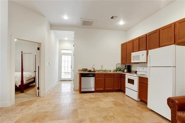 842 Toledano St, New Orleans, LA 70115 - kitchen featuring visible vents, white appliances, a sink, and brown cabinets