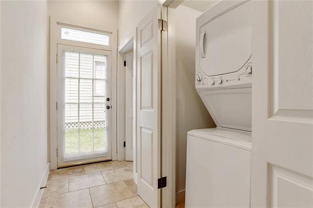 842 Toledano St, New Orleans, LA 70115 - washroom with baseboards, stacked washer / dryer, laundry area, and light tile patterned floors