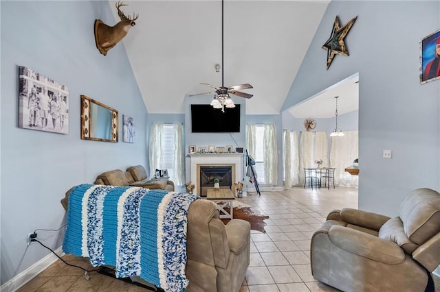 52475 Wilson Rd, Folsom, LA 70437 - living area with high vaulted ceiling, light tile patterned flooring, a ceiling fan, a glass covered fireplace, and baseboards
