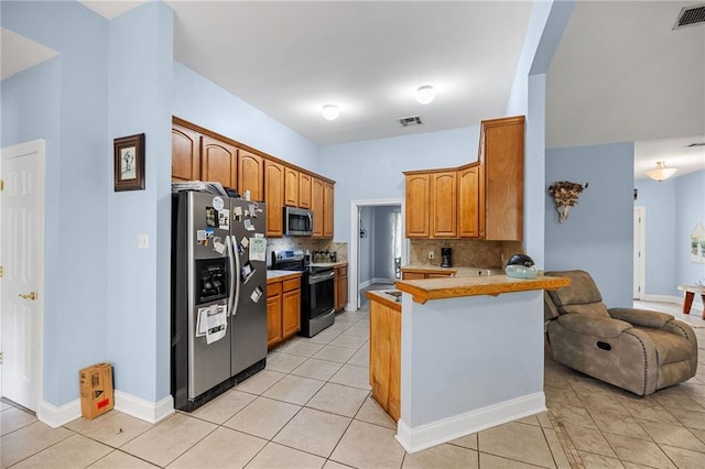 52475 Wilson Rd, Folsom, LA 70437 - kitchen featuring stainless steel appliances, a peninsula, tasteful backsplash, open floor plan, and light tile patterned floors