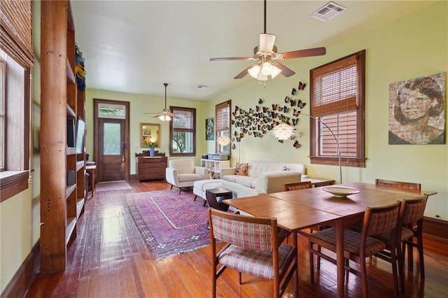 dining area with baseboards, hardwood / wood-style flooring, visible vents, and ceiling fan