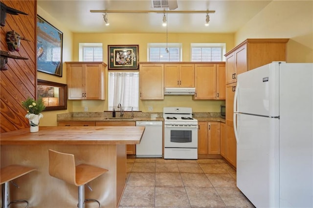 kitchen with under cabinet range hood, visible vents, a sink, white appliances, and butcher block counters