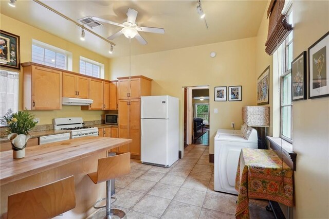 kitchen featuring butcher block countertops, track lighting, washer and clothes dryer, and white appliances